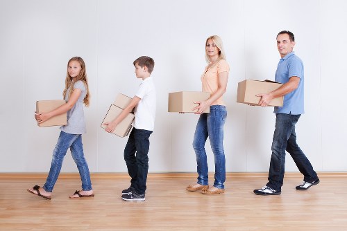 Removal team carrying furniture through a residential property in Freezywater
